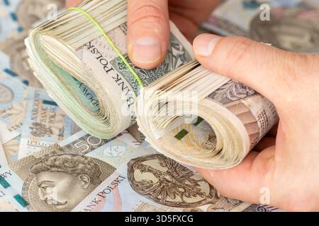 Polen Geld. Ein großer Stapel von 100, 200 und 500 Zloty-Banknoten in Händen. Finanz- und Geschäftskonzept. Barzahlung. Geld von einem abheben Stockfoto