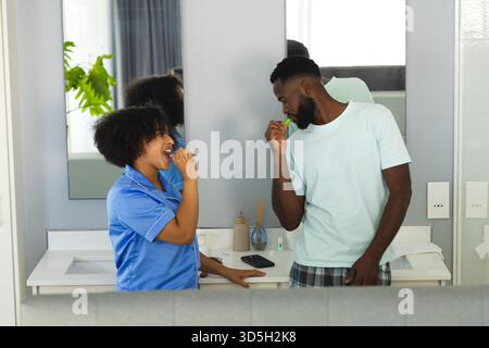 Im Badezimmer putzen Sie die Zähne zusammen, und teilen Sie sich die morgendliche Routine glücklich. Zahnbürste, Hygiene, Lebensstil, Glück Stockfoto