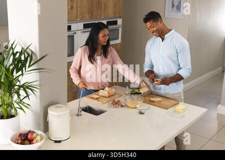 In der Küche bereiten Paare das Frühstück zusammen vor und teilen fröhliche Momente am Morgen Stockfoto