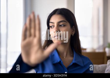Ernsthaft besorgte junge Indianerin, die Stopphand macht Stockfoto
