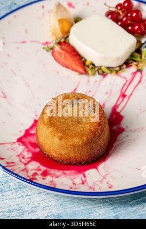 Warmes Tahini-Souffle-Dessert mit Eis und gemischten Beeren auf einem Teller Stockfoto
