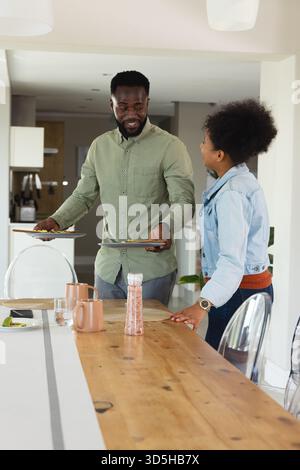 Paare in der Küche, die Tisch, Lächeln und genießen Unterhaltung zusammen Stockfoto