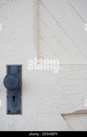 Klassischer Türknauf an einer verwitterten weißen Tür Stockfoto