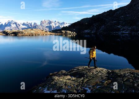 Alpensee Lago Nero bei Madonna di Campiglio in Italien, Wanderer auf einer Wanderung, Reflexion im Wasser, sonniger Herbsttag zum Wandern Stockfoto