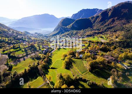 Wunderschöner Blick auf den Gardasee, umgeben von Bergen und Weinbergen in lebendigen Herbstfarben, der eine spektakuläre italienische Landschaft und das Land zeigt Stockfoto