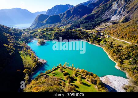 Spektakulärer Lago di Tenno in der Nähe des Gardasees im Herbst, mit lebendigen Herbstfarben, kristallklarem türkisblauem Wasser und einer atemberaubenden Alpenlandschaft. Stockfoto