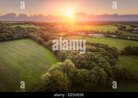 Sonnenaufgang über dem ländlichen Irland mit Flickenteppichfeldern, Hecken, Nebel und Bauernhäusern während der Tagundnachtgleiche im Herbst Stockfoto