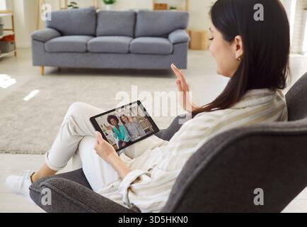 Frau zu Hause Talk Chat Online-Videoanruf auf Tablet mit verschiedenen Freunden, Mädchen mit Webcam-Konferenz Stockfoto