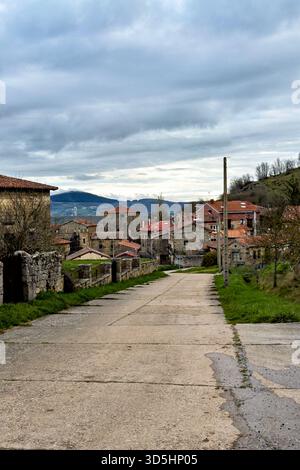 Historisches Steindorf mit roten Dächern in einem grünen Tal in der Nähe von Bergen Stockfoto