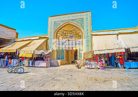 ISFAHAN, IRAN - 21. Oktober 2017: Die reich verzierten Portal der mittelalterlichen Jameh Moschee Nachbarn mit Großen Basar Läden und Ständen, am 21. Oktober in Isfahan. Stockfoto