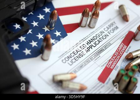 New York Schusswaffenlizenz und Handfeuerwaffe mit Kugeln auf US-Flagge Nahaufnahme. Waffenerlaubnis und Verfassung - zweites Zusatzkonzept Stockfoto