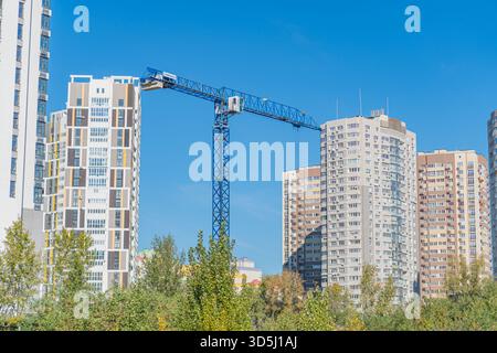 Eine urbane Landschaft voller moderner Hochhäuser, Baukräne und einem Hauch von Natur. Das Bild zeigt die dynamische Entwicklung der Stadt, Stockfoto