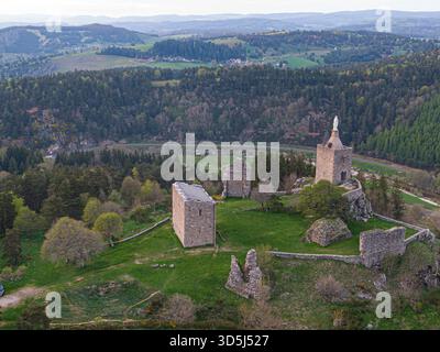Blick aus der Vogelperspektive auf die Ruinen von Luc Castel mit dem restaurierten Donjon, der Kapelle und der Statue der Jungfrau maria, die die Landschaft von lozere dominiert Stockfoto