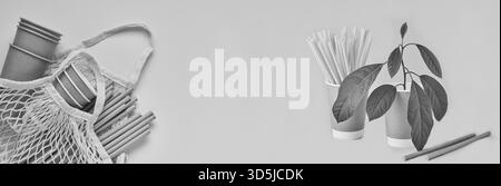 Trinkhalme aus Papier und Maisstärke, Marktbeutel aus Netzgewebe und leere Kaffeetassen aus Papier auf trendigem grauem und gelbem Hintergrund. Kein Abfall und kein Kunststoff. Draufsicht. Stockfoto