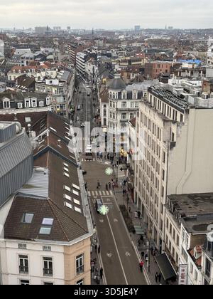 Belgien, Brüssel, 31. Dezember 2024; Hochwinkelansicht der brüsseler Stadtlandschaft mit Einkaufsstraße Rue neuve mit überlagerten covid 19-Symbolen, hoch Stockfoto
