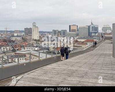 Belgien, Brüssel, 31. Dezember 2024; zwei Touristen, die auf einer modernen Holzstege spazieren, genießen den Panoramablick auf die Brüsseler Stadtlandschaft, belg Stockfoto