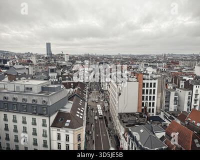 Belgien, Brüssel, 31. Dezember 2024; Brüsseler Stadtbild mit bewölktem Himmel mit dichten Gebäuden und Straßen mit vorbeifahrenden Fahrzeugen Stockfoto