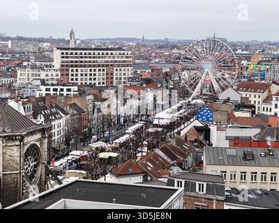 Belgien, Brüssel, 31. Dezember 2024; ein lebhafter Straßenmarkt füllt den Vordergrund, mit einem markanten Riesenrad, das die festliche Atmosphäre von unterstreicht Stockfoto