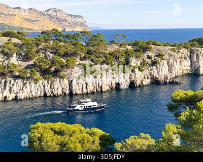 Touristenboot segelt entlang des felsigen Fjords wie der Bucht von calanque d'en vau, Cassis france Stockfoto