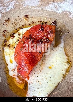Appetitliche geröstete Tomate mit geschmolzenem Weißkäse und Kräutern, mit Olivenöl getränkt Stockfoto