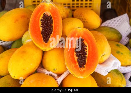 Nahaufnahme reifer Papayas, die auf dem traditionellen Lebensmittelmarkt in Phu Quoc, Vietnam, zum Verkauf angeboten werden. Vietnamesischer Straßenmarkt. Landwirtschaft, Landwirtschaft und Stockfoto