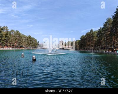 Der Brunnen des Sees ist von Wald- und Resortgebäuden umgeben Stockfoto