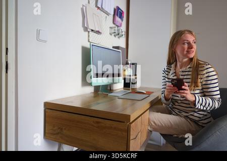 Ernsthafte junge Frau, die von zu Hause aus online arbeitet, Produktivität und Fokus Stockfoto