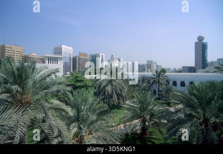 Abu Dhabi, Skyline mit dem historischen Qasr Al Hosn, umgeben von modernen Hochhäusern und üppigen Palmen. Stockfoto