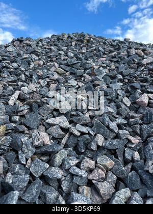 Eine Nahaufnahme eines Haufens Bauschutt vor einem blauen Himmel. Lieferung von Baumaterialien. Massengüter Stockfoto