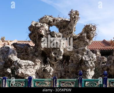 Verwitterter Gelehrtenfelsen im kaiserlichen Garten der Verbotenen Stadt unter einem klaren Winterhimmel Stockfoto