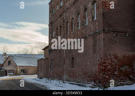 Historischer Blick auf eine alte Straße mit alten Fabrikgebäuden, Winter mit sonnigem Himmel und Schnee, Vintage Verarbeitung Stockfoto