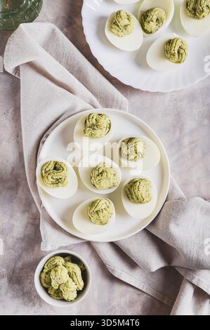 Avocadoeier als Vorspeise auf dem Teller auf der Tischplatte und vertikaler Ansicht Stockfoto