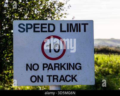 Weißes Straßenschild mit Geschwindigkeitsbegrenzung von 10 und keine Warnung beim Parken auf der Strecke in ländlicher Umgebung Stockfoto