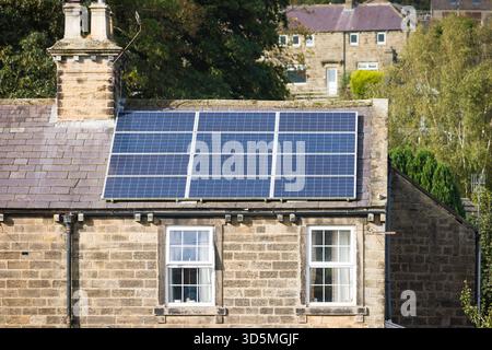 Solarpaneele auf dem Dach eines traditionellen Steinhauses im ländlichen North Yorkshire, England, Großbritannien Stockfoto