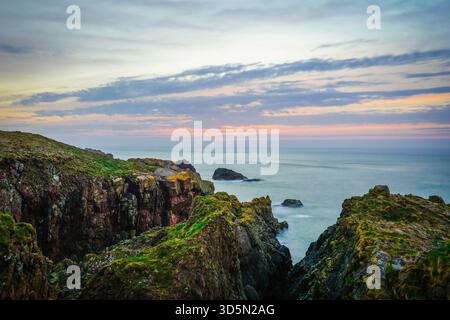 Dramatischer Sonnenuntergang/Sonnenaufgang über zerklüfteten Küstenklippen und Seestapel, Cruden Bay, Schottland Stockfoto