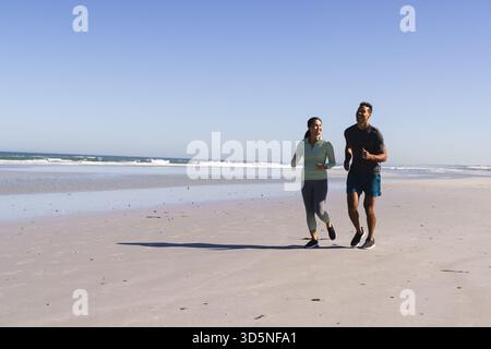 Paare Joggen am Strand, genießen sonnigen Tag und bleiben aktiv zusammen, Kopierraum Stockfoto