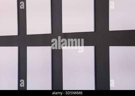 Minimaler abstrakter Hintergrund mit geometrischem Rastermuster aus weißen Papierrechtecken. Einfache, organisierte Komposition von leeren Karten, die sauber, ruhig, A Stockfoto