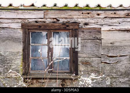Frostiges Fenster auf einer Blockhütte Stockfoto
