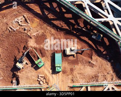 Luftaufnahme von Baggern und Muldenkippern auf einer Baustelle. Stockfoto