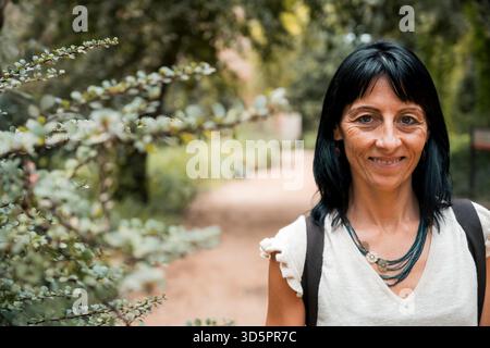 Lächelnde Frau im Wald, Nahporträt auf Naturpfad Stockfoto