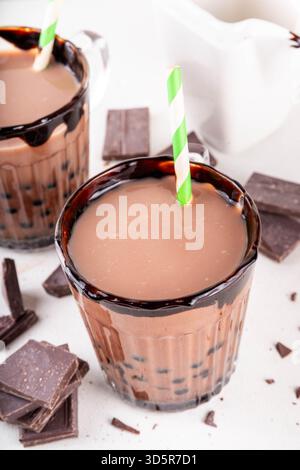 Leckerer heißer Schokoladen-Bubble-Tee. Kakao warm- oder kaltgetränk mit Tapiokakugeln und dunklem Schokoladensirup, süßes Dessertgetränk auf weißem Tisch mit c Stockfoto