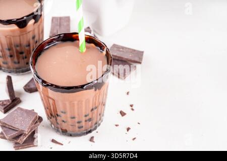 Leckerer heißer Schokoladen-Bubble-Tee. Kakao warm- oder kaltgetränk mit Tapiokakugeln und dunklem Schokoladensirup, süßes Dessertgetränk auf weißem Tisch mit c Stockfoto