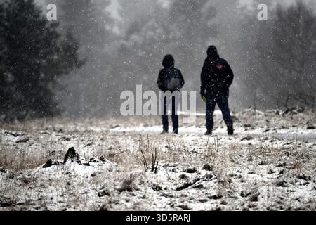Winterberg, Deutschland. November 2025. Wanderer spazieren durch die verschneite Landschaft auf der Kahler Asten. Nach einem kalten Start in die neue Woche sind die ersten Schneeflocken im Sauerland gefallen. Eine Temperatur von -0,8 Grad wurde von der Kahler Asten, dem bekannten Berg im Sauerland, berichtet. Quelle: Federico Gambarini/dpa/Alamy Live News Stockfoto