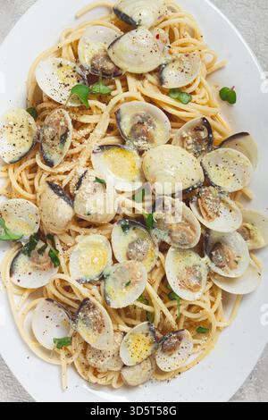 Spaghetti mit Vongole Venusmuscheln, in Sahnesauce, Carbonara, auf einem weißen Teller, hausgemacht, Draufsicht, keine Leute, Stockfoto