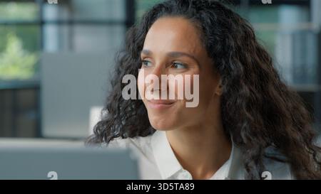 Ethnische Geschäftsfrau arbeitet am Computer im Büro lächelnd blickt weg froh hispanische Geschäftsfrau, die pc-Technologie-Mitarbeiter schreibt, kommuniziert mit Stockfoto