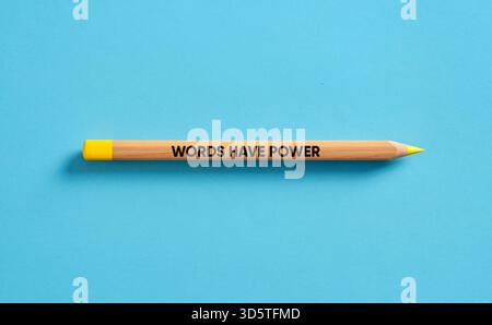 Holzbleistift mit gelber Spitze und Inschrift auf blauem Hintergrund, symbolisiert die Wirkung der Sprache Stockfoto