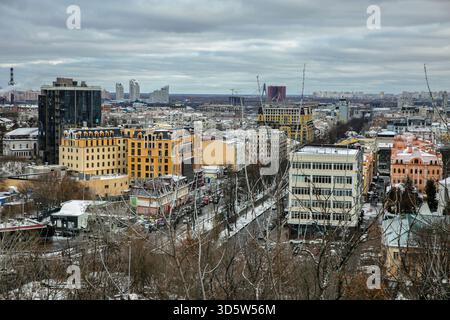 Blick aus der Vogelperspektive auf das historische Kiewer Viertel Podil im Winter mit einer Mischung aus farbenfrohen Wohn- und Geschäftsgebäuden, einschließlich gelbem Wohnblock Stockfoto