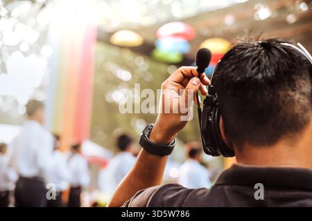 Bühnenmanager verwendet schnurloses Intercom-Headset, während Sie Live-Auftritte ansehen und leiten Stockfoto