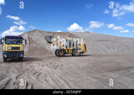 Radlader lädt ein Lkw mit Sand in einer Kiesgrube Stockfoto