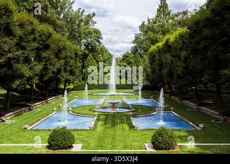 Italienischer Wassergarten in Longwood Gardens, Pennsylvania. Formale symmetrische Springbrunnen und reflektierende Pools, die von Bäumen eingerahmt werden. Keine Leute, nur redaktionell. Stockfoto